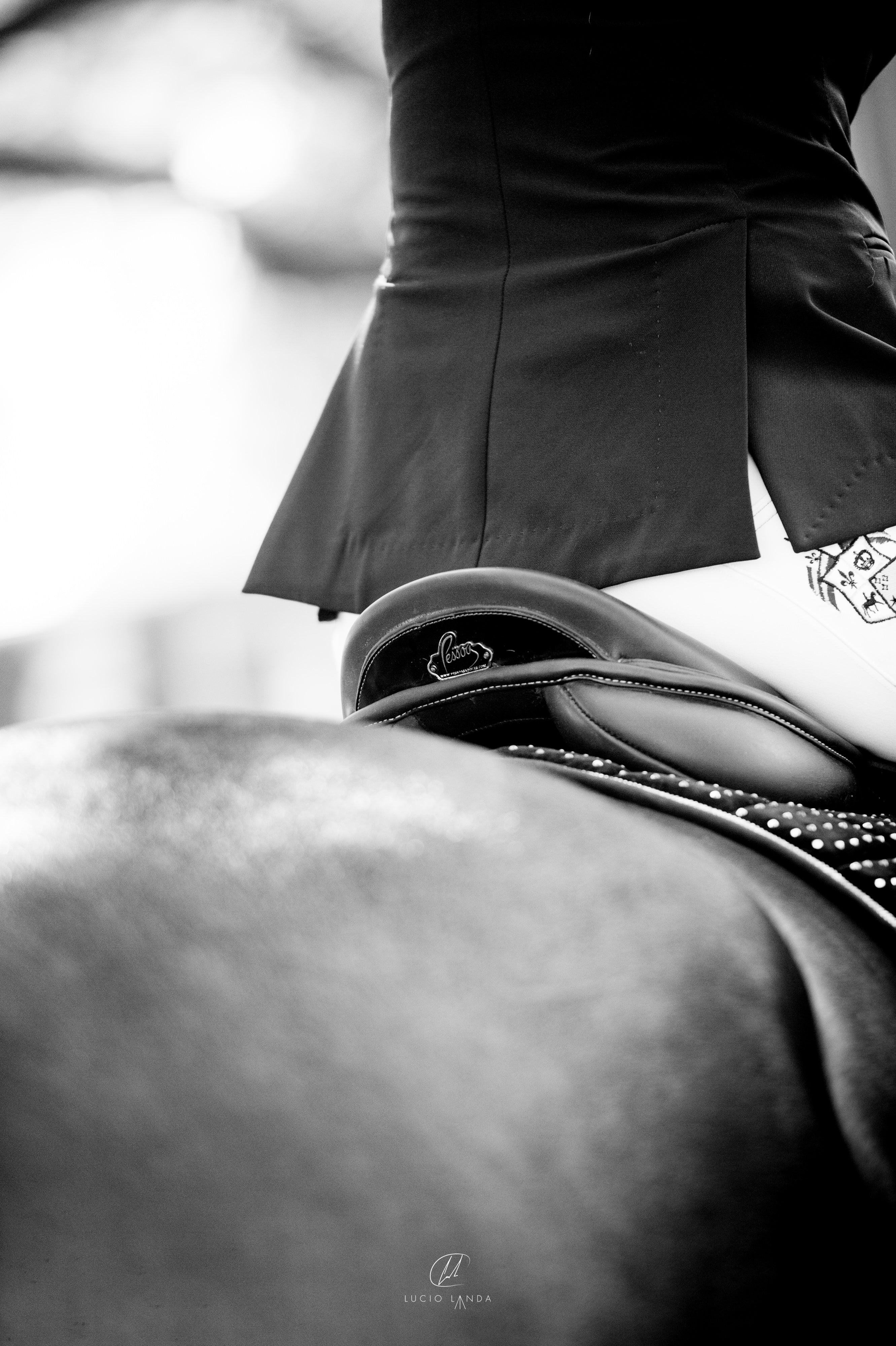 Black and white picture of rider in Pessoa Saddle with Pessoa brand visible